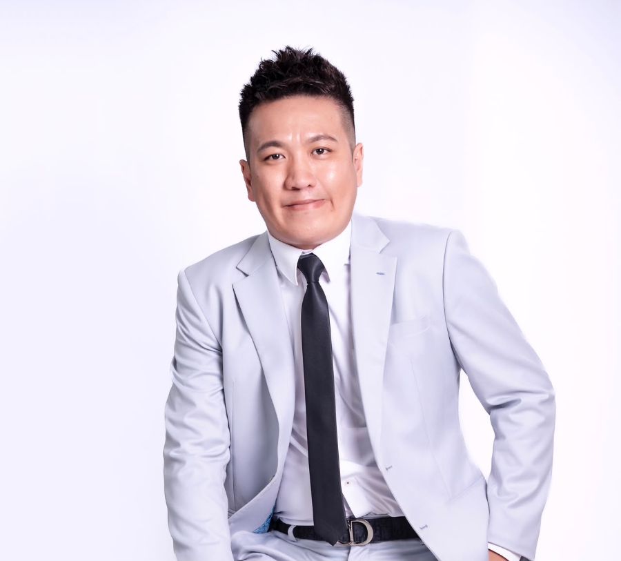 Portrait of Nelson Mak in a light grey suit and black tie