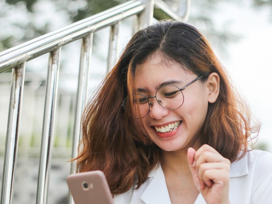 A smiling woman reading a message on her phone
