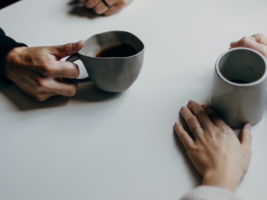 Two people talking across a table over coffee